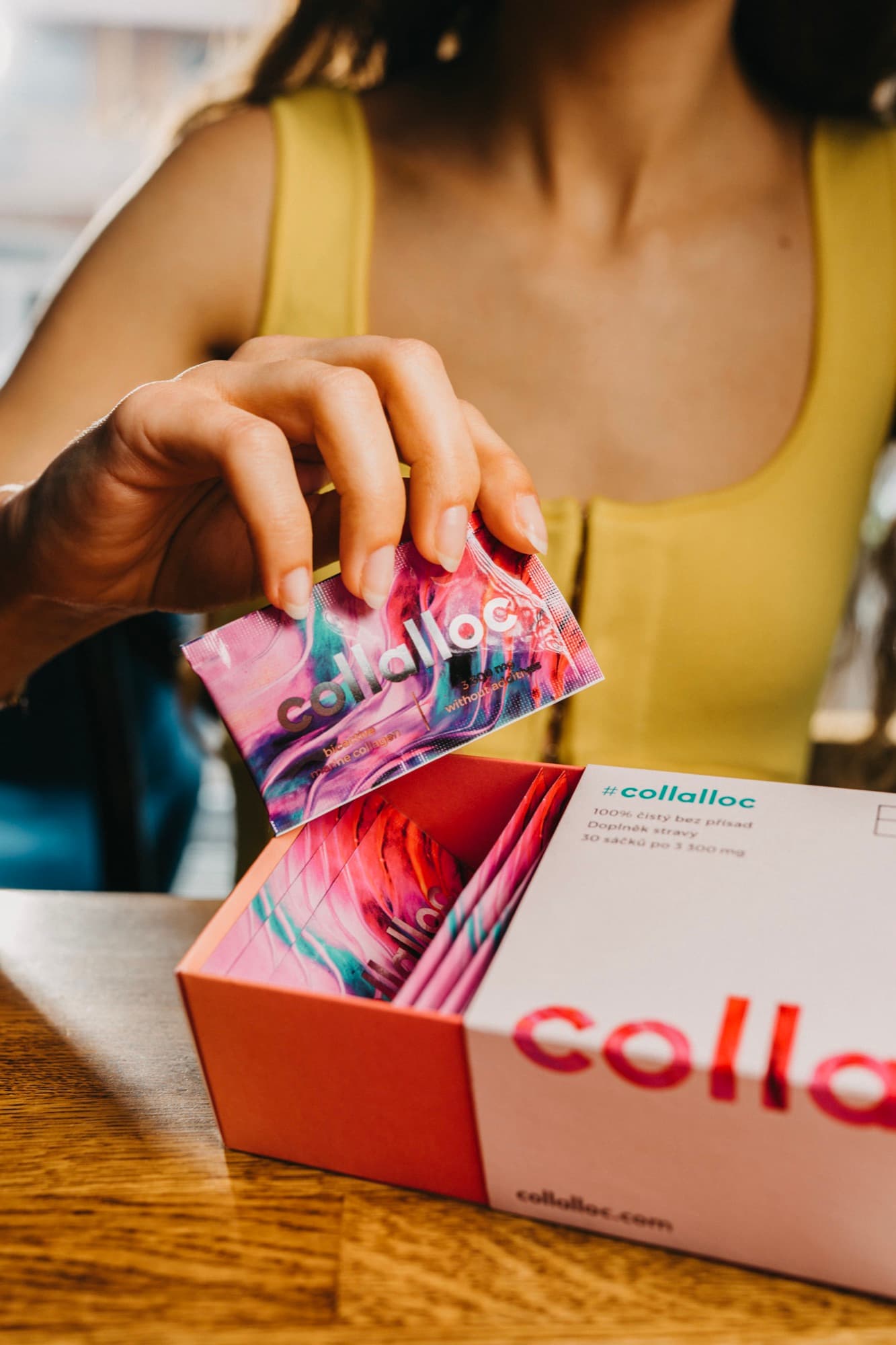 Woman taking a collalloc sachet out of the box